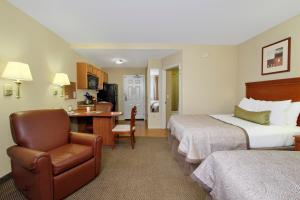a hotel room with two beds and a chair at Candlewood Suites Norfolk Airport by IHG in Norfolk +12 photos