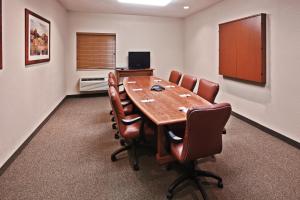 a conference room with a wooden table and leather chairs at Candlewood Suites Owasso, an IHG Hotel in Owasso
