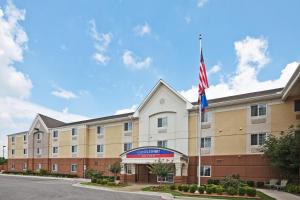 an exterior view of a hotel with an american flag at Candlewood Suites Owasso, an IHG Hotel in Owasso