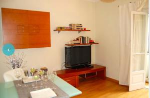 Una sala de estar con televisión y una mesa con copas de vino. en Zen Central Apartment, en Lisboa