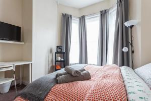 1 dormitorio con 1 cama con 2 toallas en Shirley House 1, Guest House, Self Catering, Self Check in with smart locks, use of Fully Equipped Kitchen, Walking Distance to Southampton Central, Excellent Transport Links, Ideal for Longer Stays, en Southampton