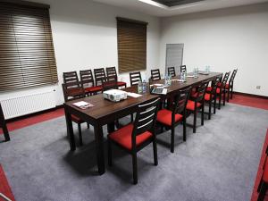 a conference room with a long table and chairs at Hotel Otoliński in Płock