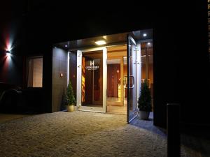 an open glass door of a building at night at Hotel Otoliński in Płock