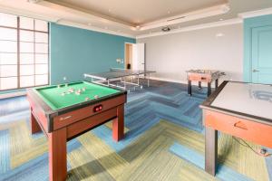 a room with a pool table and two tables at Holiday Inn Club Vacations Sunset Cove Resort in Marco Island