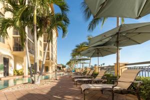 a resort pool with chairs and umbrellas and palm trees at Holiday Inn Club Vacations Sunset Cove Resort in Marco Island