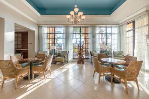 a dining room with tables and chairs and windows at Holiday Inn Club Vacations Sunset Cove Resort in Marco Island