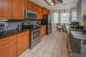 a kitchen with wooden cabinets and stainless steel appliances at Holiday Inn Club Vacations Sunset Cove Resort in Marco Island