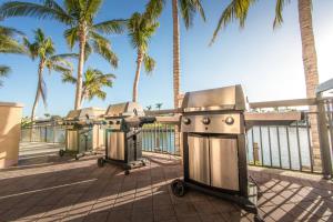 a grill on a sidewalk next to palm trees at Holiday Inn Club Vacations Sunset Cove Resort in Marco Island