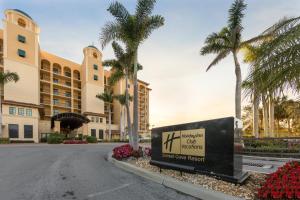 a sign in front of a building with palm trees at Holiday Inn Club Vacations Sunset Cove Resort in Marco Island