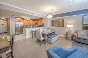 a living room with a table and a kitchen at Holiday Inn Club Vacations Sunset Cove Resort in Marco Island