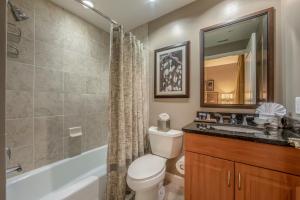 a bathroom with a toilet and a sink and a tub at Holiday Inn Club Vacations Sunset Cove Resort in Marco Island