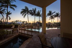 a resort pool with palm trees and a sunset at Holiday Inn Club Vacations Sunset Cove Resort in Marco Island