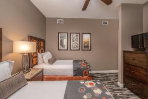 a bedroom with two beds and a flat screen tv at Holiday Inn Club Vacations Sunset Cove Resort in Marco Island