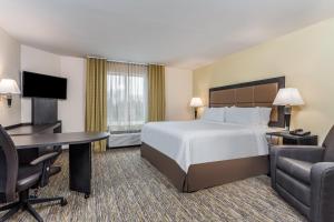 a hotel room with a bed, chair, desk and a television at Candlewood Suites Bensalem - Philadelphia Area, an IHG Hotel in Bensalem
