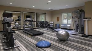 einen Fitnessraum mit mehreren Laufbändern und einem großen Spiegel in der Unterkunft Candlewood Suites - Newark South - University Area, an IHG Hotel in Newark