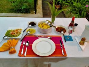 a table with a plate of food on it at Surathura homestay in Kurunegala