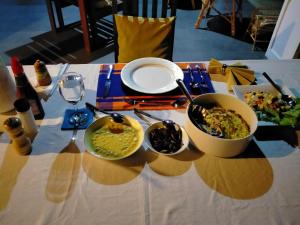 Surathura homestay في كورونيغالا: طاولة مع أطباق من الطعام على طاولة