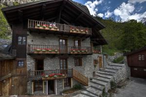 une maison avec des boîtes de fleurs sur ses balcons dans l'établissement Residence CAV Emile Rey, à Courmayeur