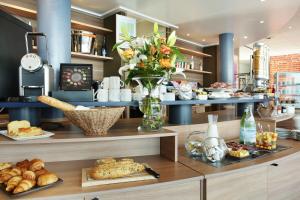 a bakery with bread and flowers on a counter at Suite-Home Orléans-Saran in Saran