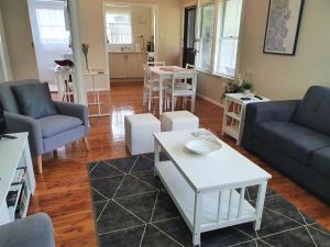 a living room with a couch and a table at Ronelle Cottage in Berrima +42 photos