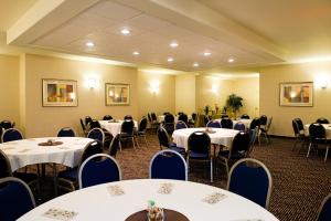 uma sala cheia de mesas e cadeiras com mesas brancas em Holiday Inn Express & Suites-Regina-South, an IHG Hotel em Regina