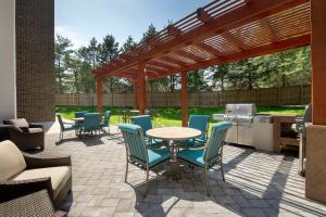 a patio with a table and chairs and a grill at Candlewood Suites Alexandria West, an IHG Hotel in Alexandria