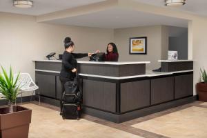 two women standing at a counter in a hotel lobby at Candlewood Suites Alexandria West, an IHG Hotel in Alexandria