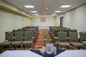 Quality Inn & Suites في ريجينا: غرفة بها صفوف من الكراسي وطاولة