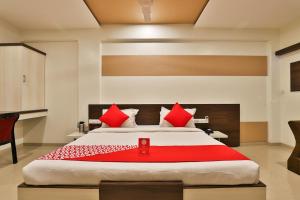 a bedroom with a large bed with red pillows at HOTEL OSTRIA in Surat