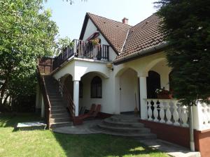 ein kleines weißes Haus mit einer Treppe und einem Balkon in der Unterkunft Zsoli Vendégház in Alsópáhok