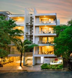 a white building with a palm tree in front of it at Lords Eco Inn Bengaluru Jayanagar in Bangalore