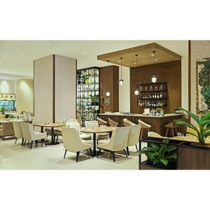 Summit Hotel Greenhills في مانيلا: مطعم بطاولات وكراسي وبار