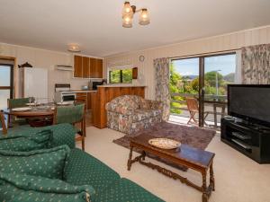 a living room with a couch and a table at Jacaranda Lodge - Whangamata Upstairs Unit in Whangamata