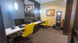 um escritório com uma secretária com um computador e cadeiras amarelas em Holiday Inn Express Thunder Bay, an IHG Hotel em Thunder Bay