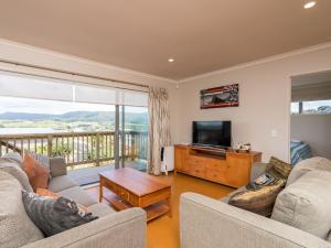 un soggiorno con 2 divani e una TV di Driftwood Views - Mangawhai Heads Holiday Home a Mangawhai
