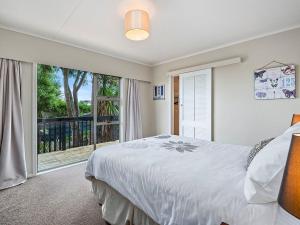a bedroom with a bed and a large window at Taupo Panorama - Lake Taupo Holiday Home in Taupo