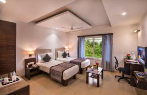a hotel room with a bed and a desk at Lords Eco Inn Bengaluru Jayanagar in Bangalore