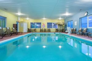 una gran piscina con sillas y una mesa en Holiday Inn Express Hotel & Suites Richmond, an IHG Hotel, en Richmond
