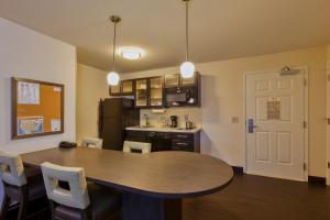 a room with a table and chairs and a kitchen at Candlewood Suites Tucson, an IHG Hotel in Tucson