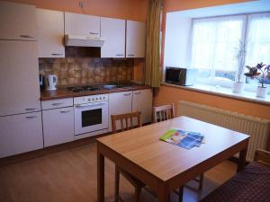 a kitchen with a wooden table and a table and a dining room at Schusterhäusl in Wörschach