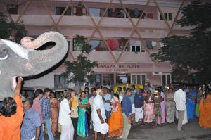 un grupo de personas de pie en frente de un edificio con un elefante en Srirangam Service Apartment, en Tiruchchirāppalli