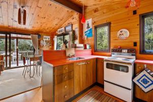 a kitchen with wooden cabinets and a stove top oven at Piwakawaka ā Pukawa - Pukawa Bay Holiday Home in Kuratau +16 photos