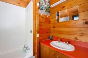 a bathroom with a sink and a bath tub and a sink at Piwakawaka ā Pukawa - Pukawa Bay Holiday Home in Kuratau