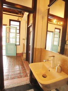 a bathroom with a white sink and a mirror at With Inn Hostel in Kaohsiung