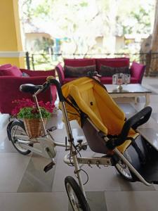 a yellow baby stroller on a bike in a living room at Chiangkhong Teak Garden Riverfront Onsen Hotel- SHA Extra Plus in Chiang Khong