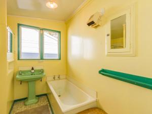 un bagno con lavandino e vasca da bagno di Kaha Cottage - Rangataua Holiday Home a Ohakune