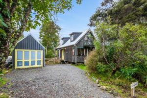 KuratauにあるParehopu Lake House - Taupo Holiday Homeの黄色と青のガレージのある家