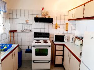 W kuchni znajduje się biała kuchenka i kuchenka mikrofalowa. w obiekcie Sunset Cove 2 w mieście Margate