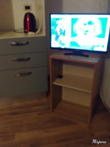 TV en un soporte de madera con tocador en Appartamento Masha Como, en Mozzate