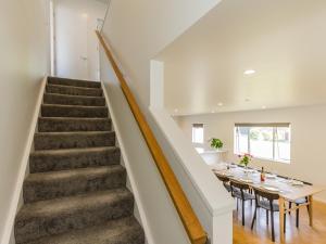 uma escada que leva até uma sala de jantar com uma mesa em The Timber Manor - Ohakune Holiday Home em Ohakune